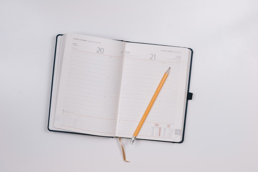 Lifter sketching a custom gym logbook layout on grid paper beside a barbell