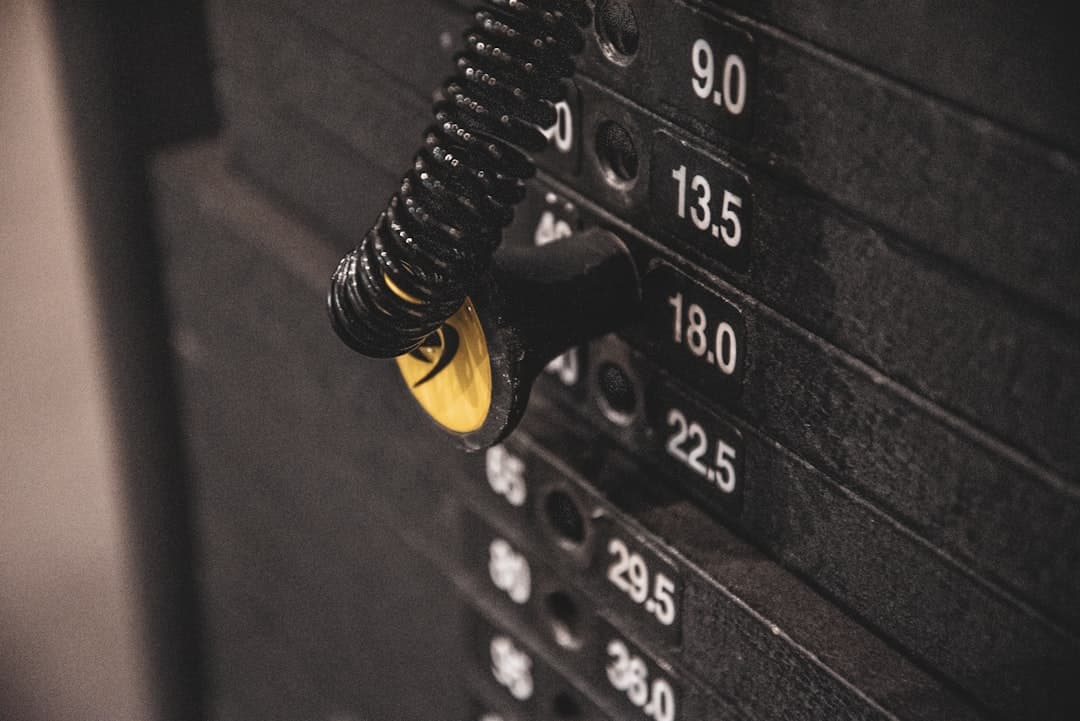 Various workout tracking methods spread across a gym bench — logbook, phone with app, smartwatch, notebook, and spreadsheet printout