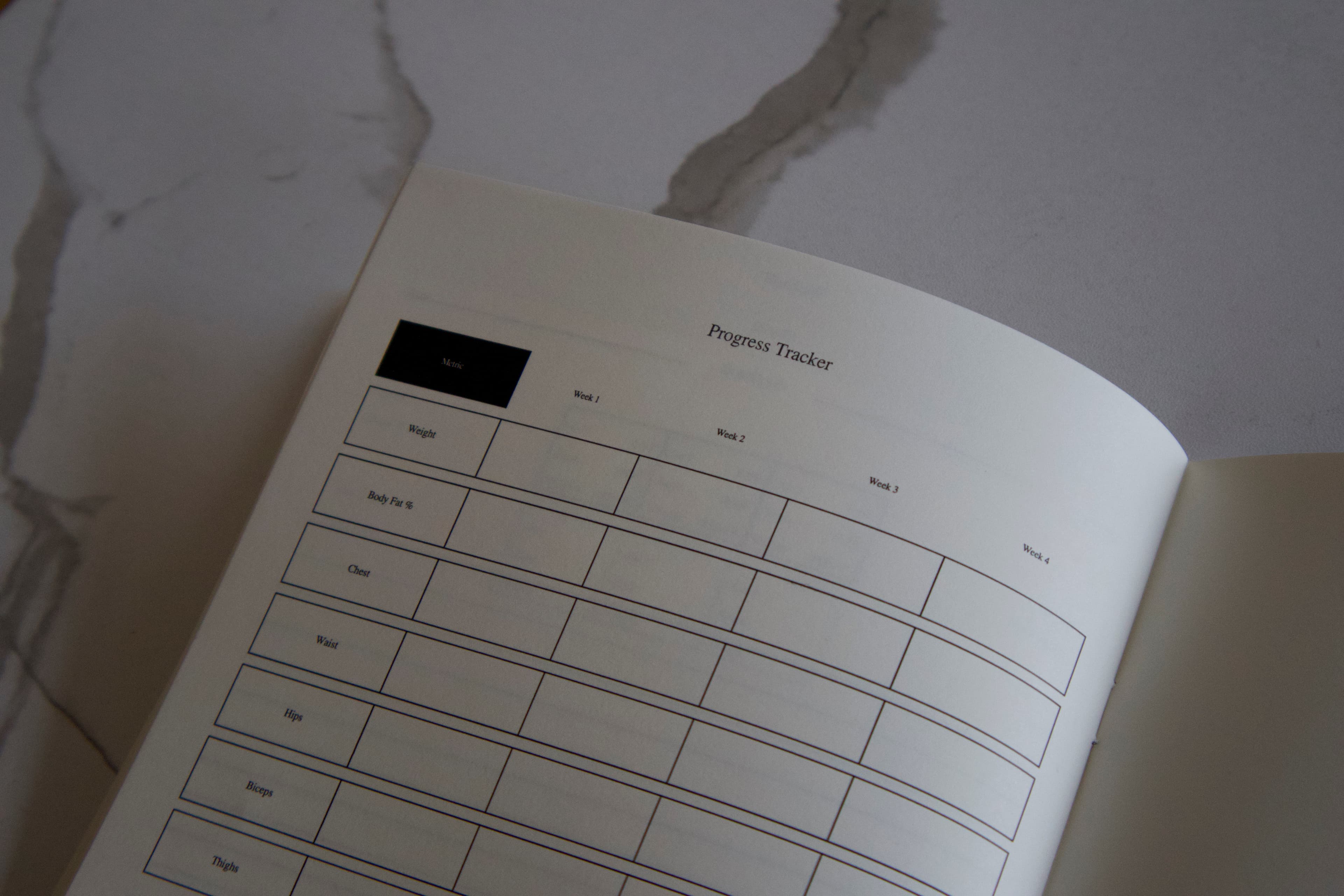 Open powerlifting logbook showing daily training spread